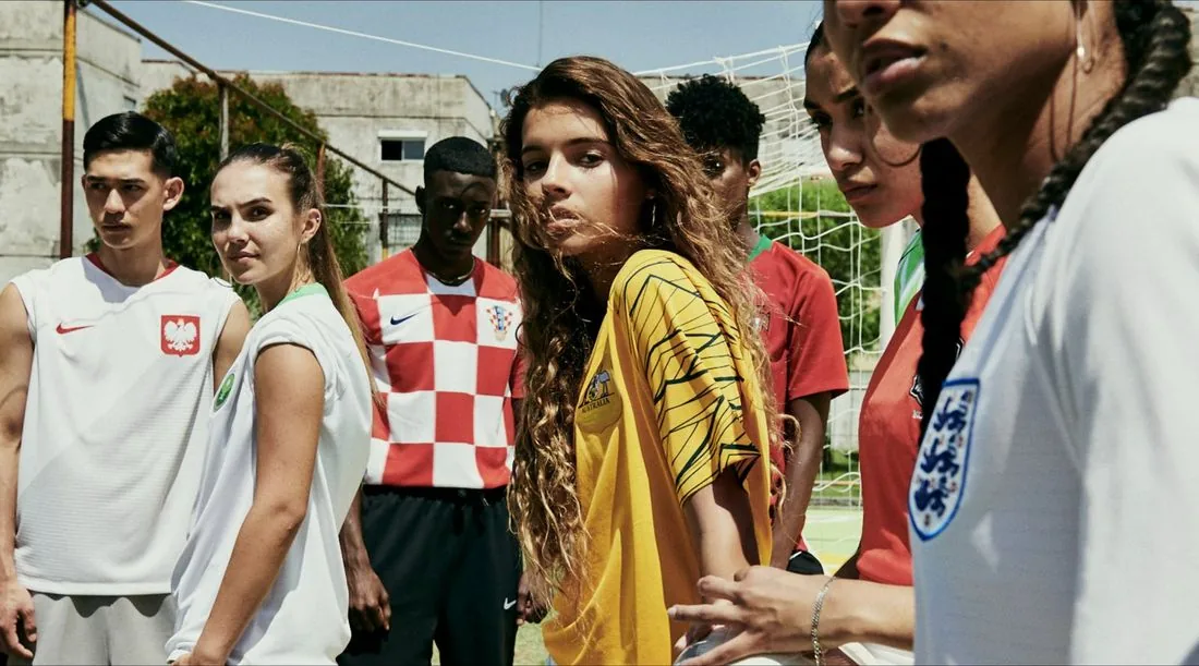 Young people in Nike national-team jerseys, including Croatia, Australia, Poland and England, gathered on a street football pitch